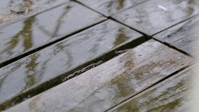 raindrops fall on wooden brown flooring in the street. rainy weather. slow motion video