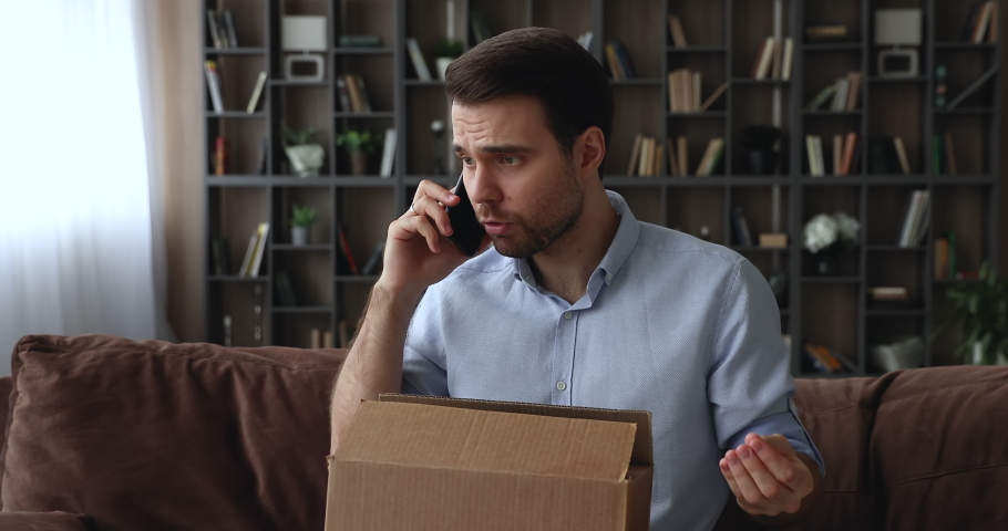 Angry unhappy young man holding phone call conversation with seller or delivery company manager, dissatisfied with wrong order or crashed item when opened carton parcel, negative shopping experience. Royalty-Free Stock Footage #1079755505