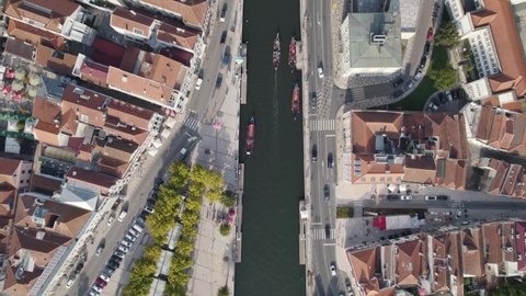 Moliceiros with tourists on busy Ria de Aveiro urban canals. Top down aerial cityscape