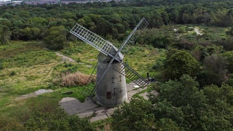 Bidston hill disused rural flour mill restored traditional wooden sail windmill Birkenhead aerial view dolly left