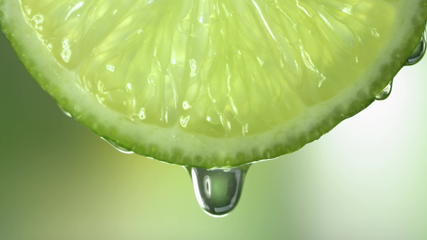 Slow Motion Macro Shot of Flowing Lime Juice from Lime Slice | Shutterstock HD Video #1079772947
