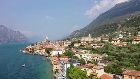 Aerial video view from waterfront of the historic city of Malcesine, the Scaliger Castle in Malcesine, the port and restaurants of old town, on the eastern shore of Lake Garda , Italy - K4 movie