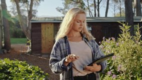 Caucasian female farmer standing outdoors swiping on digital tablet 