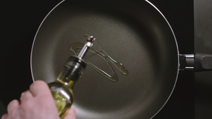 TOP VIEW: Man pouring cooking oil on the frying pan