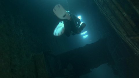 MEDITERRANEAN SEA, CYPRUS - AUGUST, 2021: Scuba diver swims inside of the shipwreck Swedish ferry MS Zenobia. Wreck diving. Mediterranean sea, Cyprus