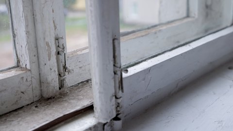 a process of old dirty white wooden window vacuum cleaning