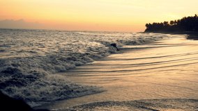 Video on tranquil idyllic summer evening twilight on ocean coastline with foaming waves on sandy beach, beautiful scenic romantic dawn on seaside in morning sky 