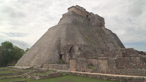 UXMAL, YUCATAN, MEXICO - MAY 2021: Ruins of the Pyramid of the Magician in Uxmal, an ancient Mayan city in Yucatan peninsula. Panning shot.