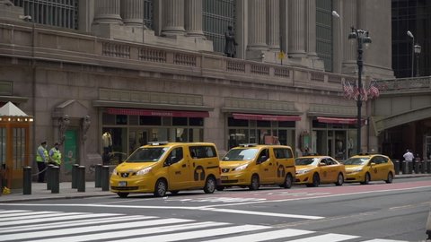 NEW YORK, USA - MAY, 18, 2021: Yellow taxi cab cars parked at Grand Central Terminal railway station. Transport on a NYC city at midtown Manhattan. City street.