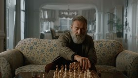 Old aged man playing chess board alone at home. Single focused mature model playing chess in luxury home interior. Rich senior player enjoy smart strategy game indoors. Wisdom retirement life concept - Powered by Shutterstock - Get 15% off with code: PIKWIZARD15