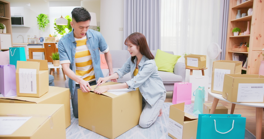 Happy asian couple receive packing parcel after online shopping at home and there is a new robot vacuum cleaner in opening delivery box Royalty-Free Stock Footage #1079814644