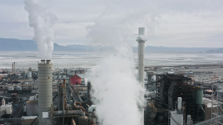 Chemical plant pumping out smoke and steam. Industrial air pollution and global warming disaster caused by the greenhouse effect. Sears city aerial panorama, California, United State of America 4K