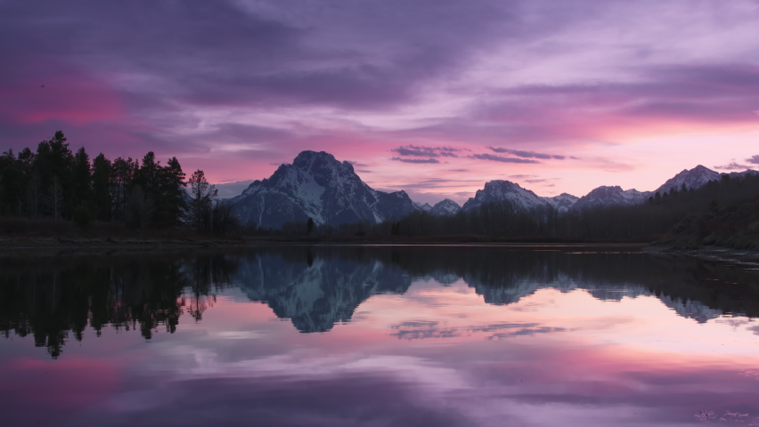 Summer sunset sky. Panoramic landscape sunset in Nature park. 4K Grand Teton National park, USA. Pink skyline sunset mountains. Wilderness travel colorful sky. Vibrant sunset reflecting in lake waters Royalty-Free Stock Footage #1079820722