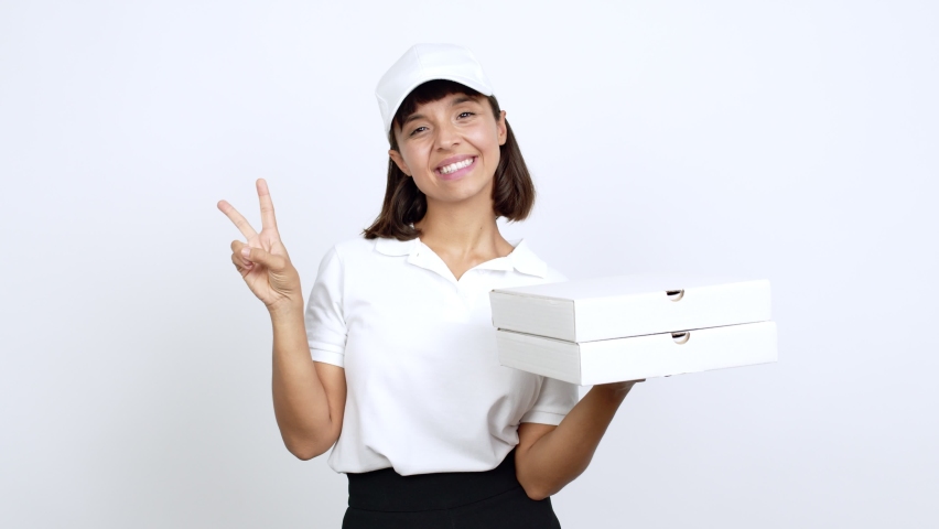 Young woman holding a pizza smiling and showing victory sign with a cheerful face over isolated background