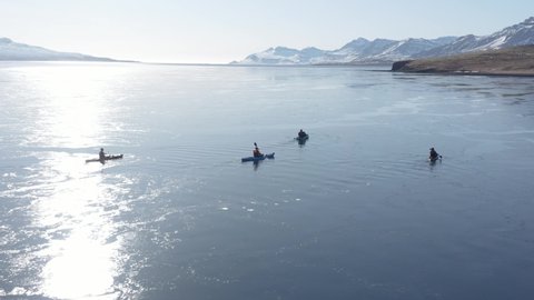 Canoe adventure trip in waveless Eskifjörður fjord with bright sunlight