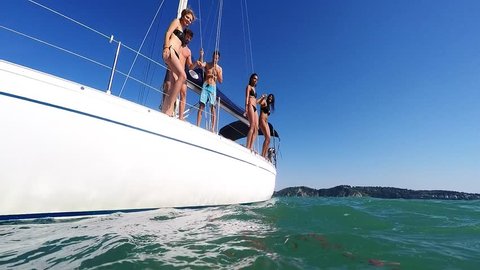  Happy people jumping into water from a boat - Friends diving and having fun on a summer vacation - Tourists on excursion with a sailing ship