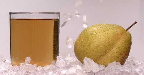 Yellow pear juice in cold ice with fresh and yummy pears, natural and organic fruits in white background. Filmed high speed cinema camera, slow motion footage, 8K downscale, 4K.