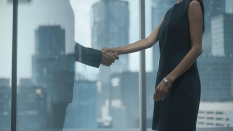 Female and Male Business Partners Meet in Office, Shake Hands. Corporate CEO and Finance Manager Have Meeting in City Office. Businesspeople Came to Discuss Real Estate Purchase and Marketing Project.