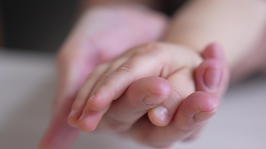 mom holds the hand of a newborn. close-up baby hand. hospital caring happy family medicine concept. baby newborn holding mom hand close-up indoor. mom takes care of the baby in the hospital Royalty-Free Stock Footage #1079854274