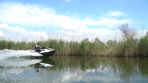 Kherson, Ukraine, 08.20.2021 A man driving along  on a river jet boat, jet ski.Man riding personal water craft on lake. The man riding a water bike jetski