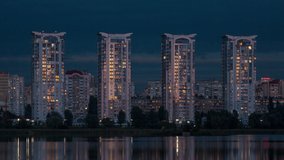 Tall houses of a big city near the river, sunset, time-lapse