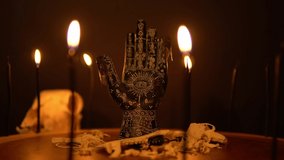 Black fortune teller hand with constellations on the reader table with magic animal bones, goat skull and cicada insects. Alchemy spirituality symbolic background with candle smoke and fog. - Powered by Shutterstock - Get 15% off with code: PIKWIZARD15