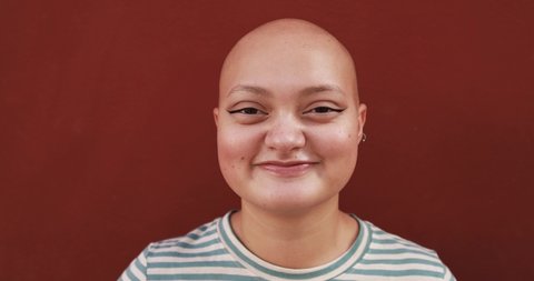 Bald girl posing and smiling in front of camera - Real people, diversity and female power concept
