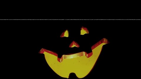 Halloween glowing pumpkins with black background. Orange glow light inside of carved pumpkin head. Dark smile face. TV noise and glitch effect. Jack-o-lantern. Will-o-the-wisp Flashing and glow light