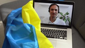 laptop with video conference and presentation near the flag of ukraine