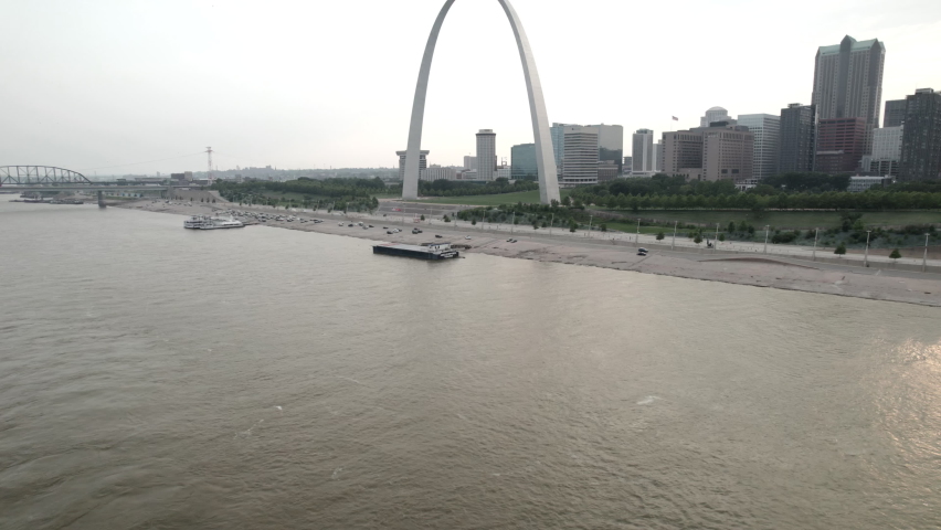 Aerial pedestal up revealing Gateway Arch in St. Louis over Mississippi River.