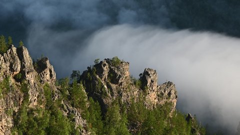 Clouds drifting in a valley among scenic rocks at Ural mountains. Nature of Bashkortostan, Russia
