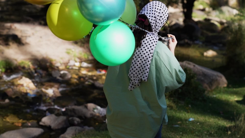 Beautiful girl with balloons in nature 