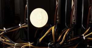 The Ethereum logo goes out against the background of the video cards from the mining farm placed in a row. High quality 4k footage