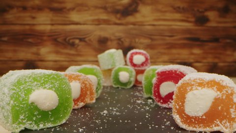 Colorful Turkish delight sweets on wooden background, zoom in video