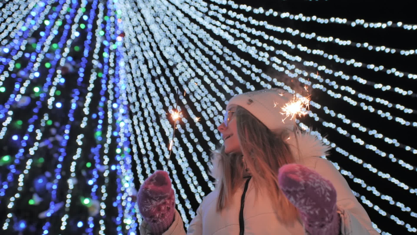 Young girl posing with sparklers against the background of New Year