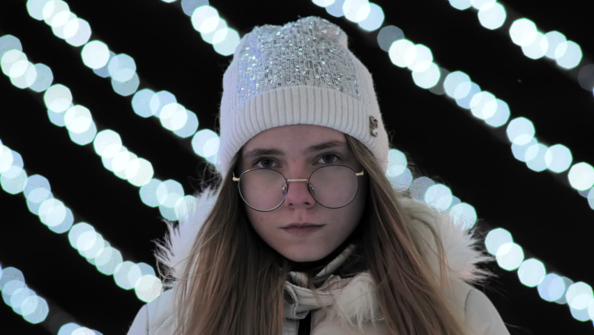 Sad girl in the evening in the city against the background of New Year