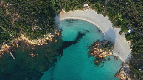 View from above, stunning aerial view of a green coast with the beautiful Prince Beach (Spiaggia del Principe) a white sand beach bathed by a turquoise water. Sardinia, Italy.