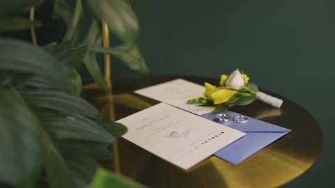 Wedding rings and invitations, on a green background
