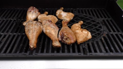 chicken legs on a wire rack on a gas grill