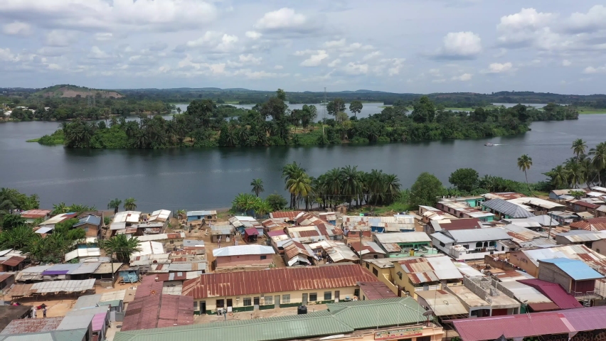 Aerial Adome village Volta River island Ghana Africa. Volta River is the main river system in the West African country of Ghana. The Adome Bridge crosses the river. The Akosombo Dam upstream. Royalty-Free Stock Footage #1079916218