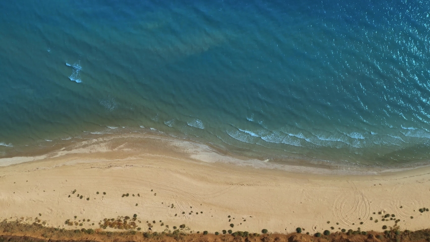 Top Aerial Drone View of a Deserted Beach and the Sea Calm Waves