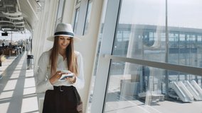 Elegant beautiful business girl holding travel tickets and using phone, happy girl looking at camera in airport terminal. Fashion woman portrait. Airport terminal. Business trip - Powered by Shutterstock - Get 15% off with code: PIKWIZARD15