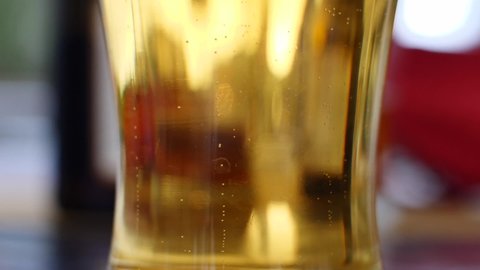 Glass of beer with bubbles rising to the surface. Super slow motion HD