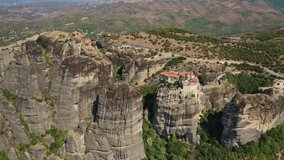Aerial drone video of iconic Monastery of Varlaam at Meteora monasteries complex of immense natural pillars and hill-like rounded stones, an Unesco World Heritage site, Thessaly, Greece