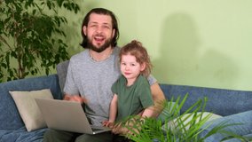 Dad and daughter video blog at home on couch with laptop. have fun family talk happy dance. Look into frame speak. Looking into camera. Man and girl with laptop on sofa. Sing song together play Hug.