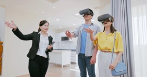 asian young couple with real estate agent visiting house for sale or rent - two people wearing VR headsets and realtor introducing building