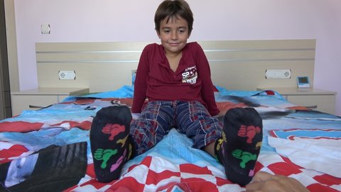 Fethiye, Turkey - 26th of August 2021: 4K Mother takes off sock from child and tickles his sole