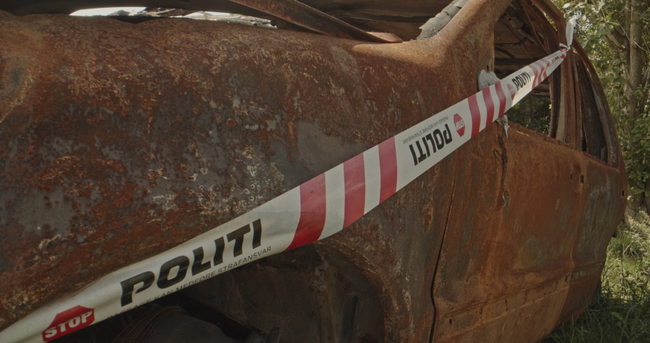 A burned out car on the middle of the road