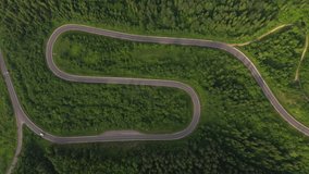 Top view from a quadcopter flying over a winding road. Location place Carpathian mountains, Ukraine, Europe. Cinematic aerial shot. Explore the beauty of world. Filmed in 4k, drone video.
