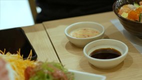4k video of using chopctick pick slamon sashimi dipping into soy sauce, raw fish Japanese style food.